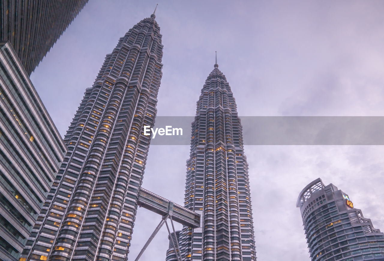 Low angle view of petronas towers against cloudy sky