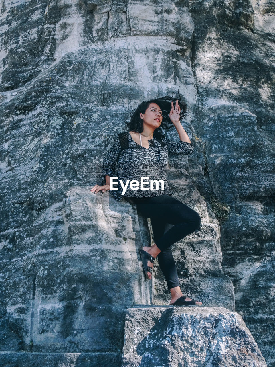 Low angle view of woman standing on rock formation