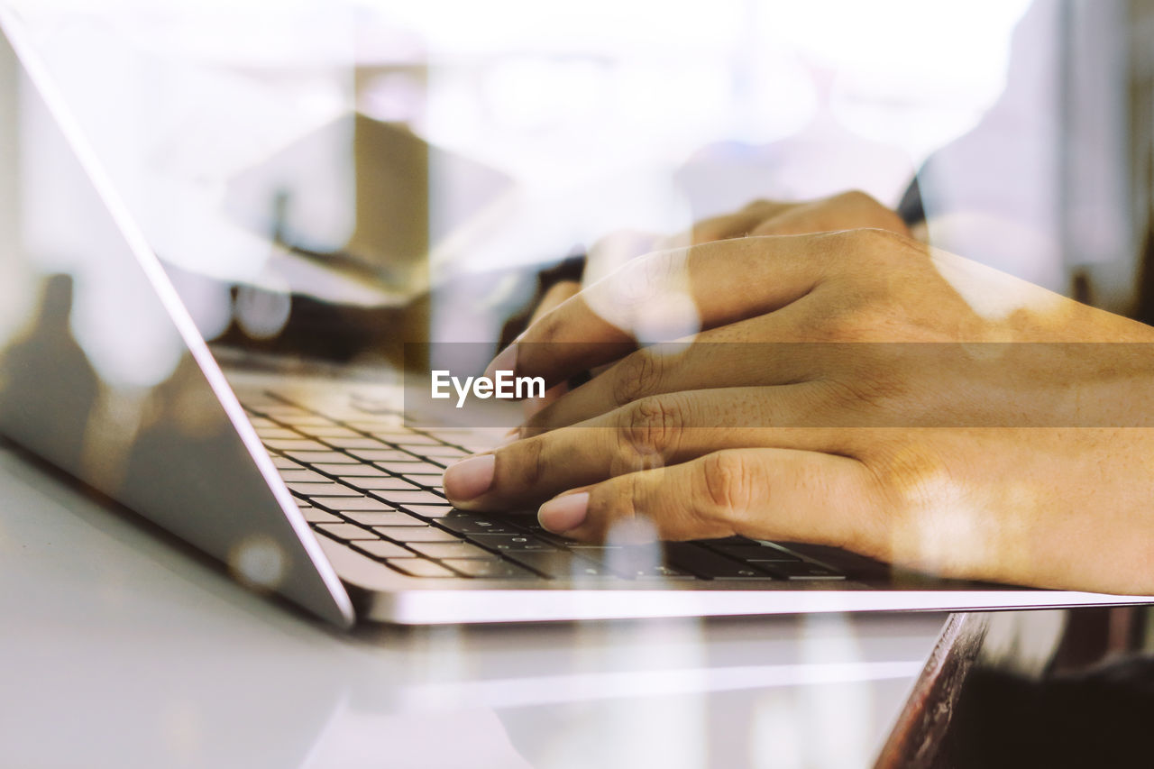 Close up image of man typing on laptop keyboard