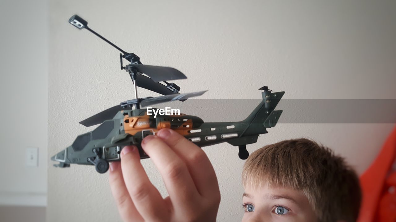 Boy playing with toy helicopter