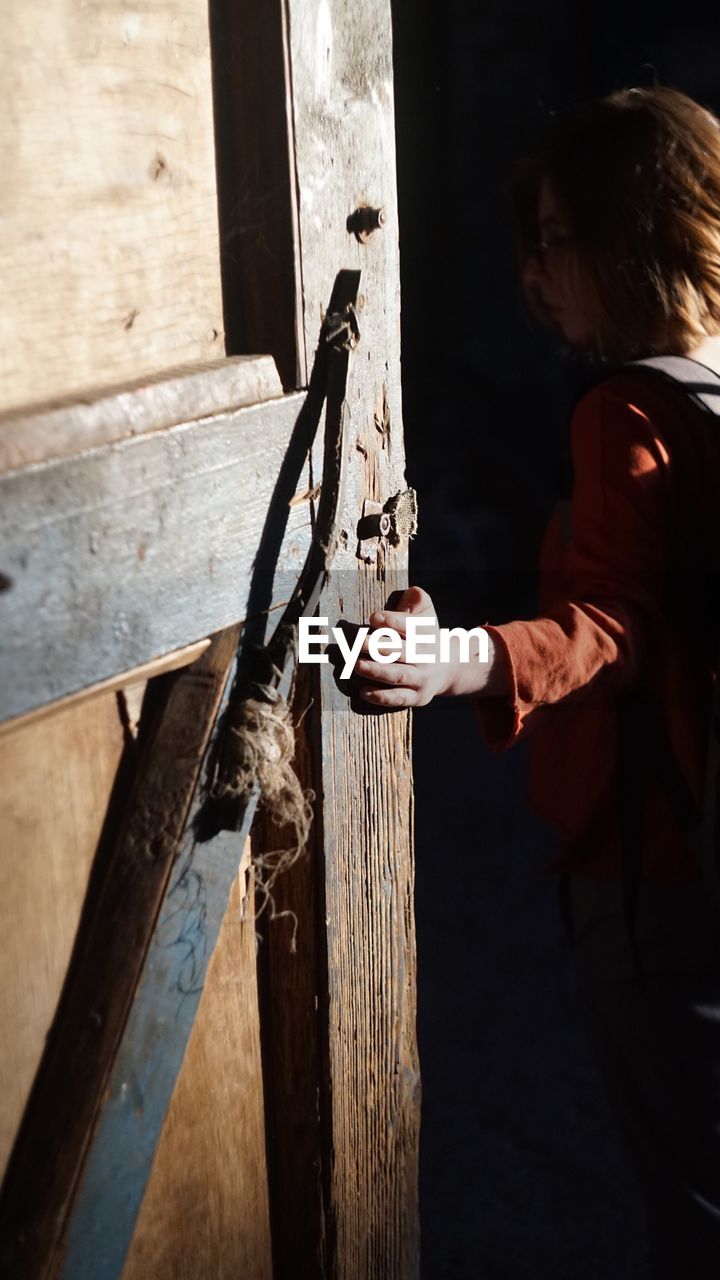 Woman hand on wooden door