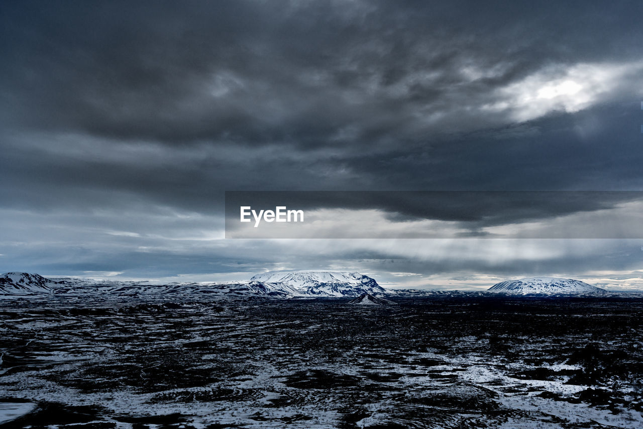 SNOW COVERED LANDSCAPE AGAINST CLOUDY SKY