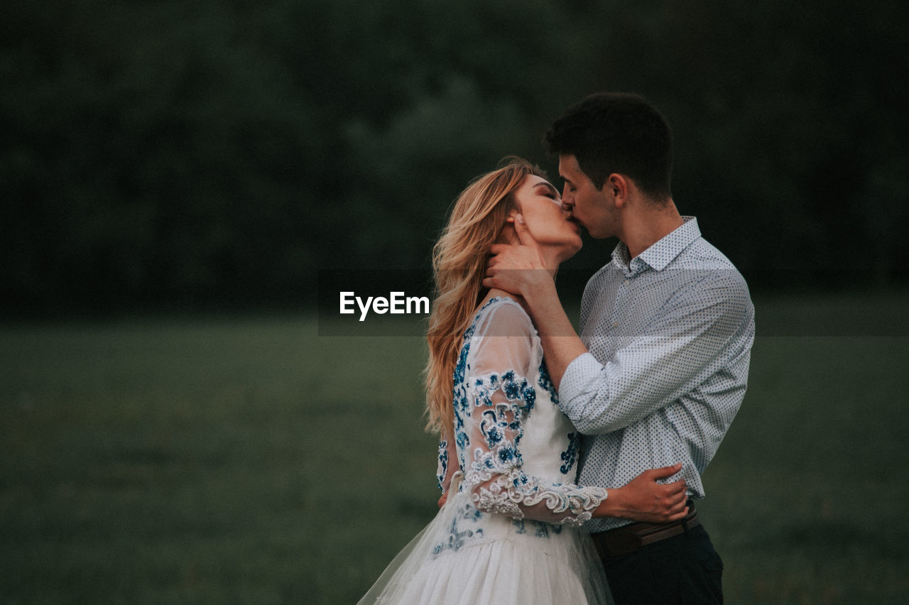 Couple kissing while standing outdoors