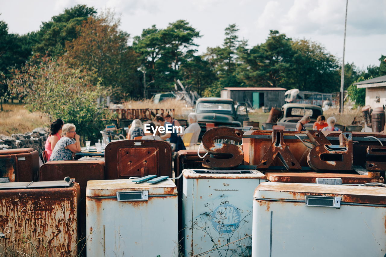 Rusty objects in city against trees