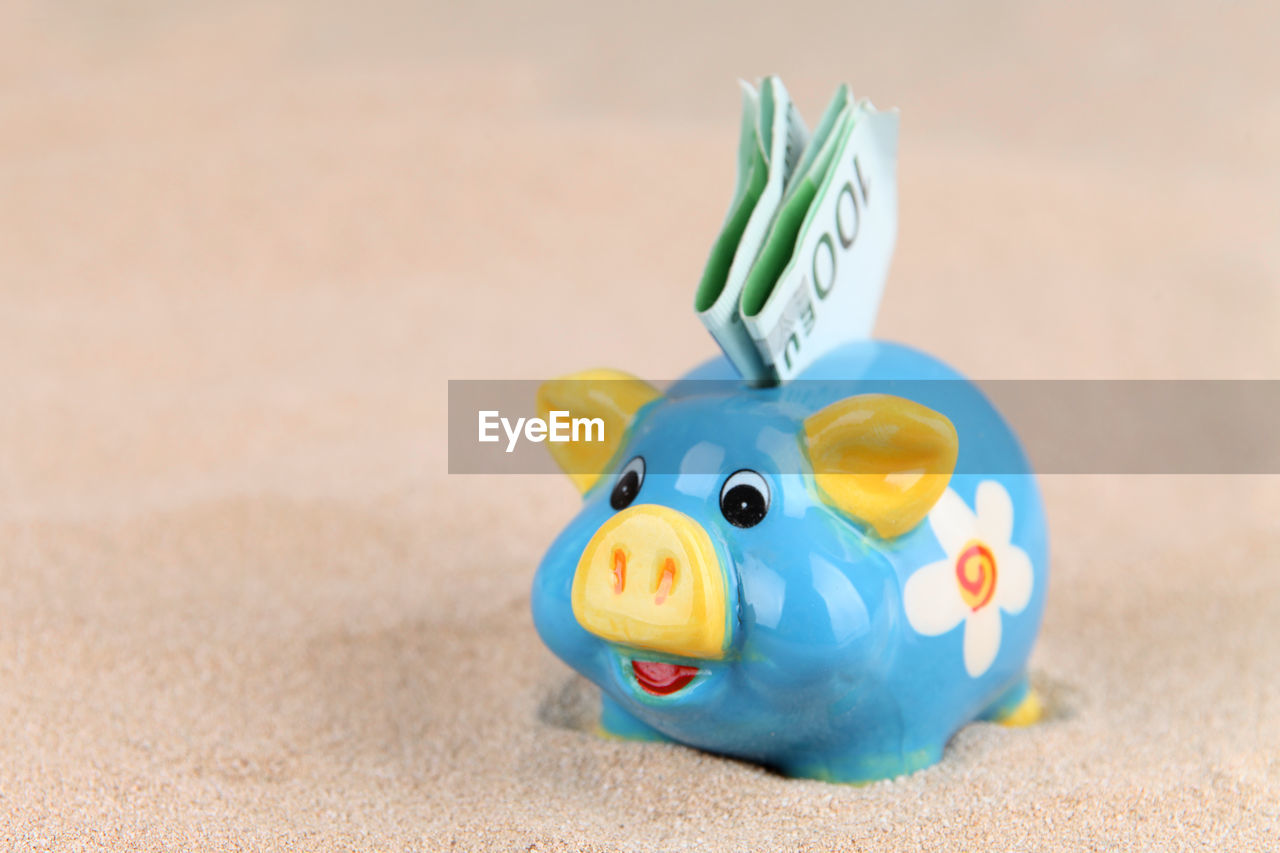 Close-up of paper currency in piggy bank on table