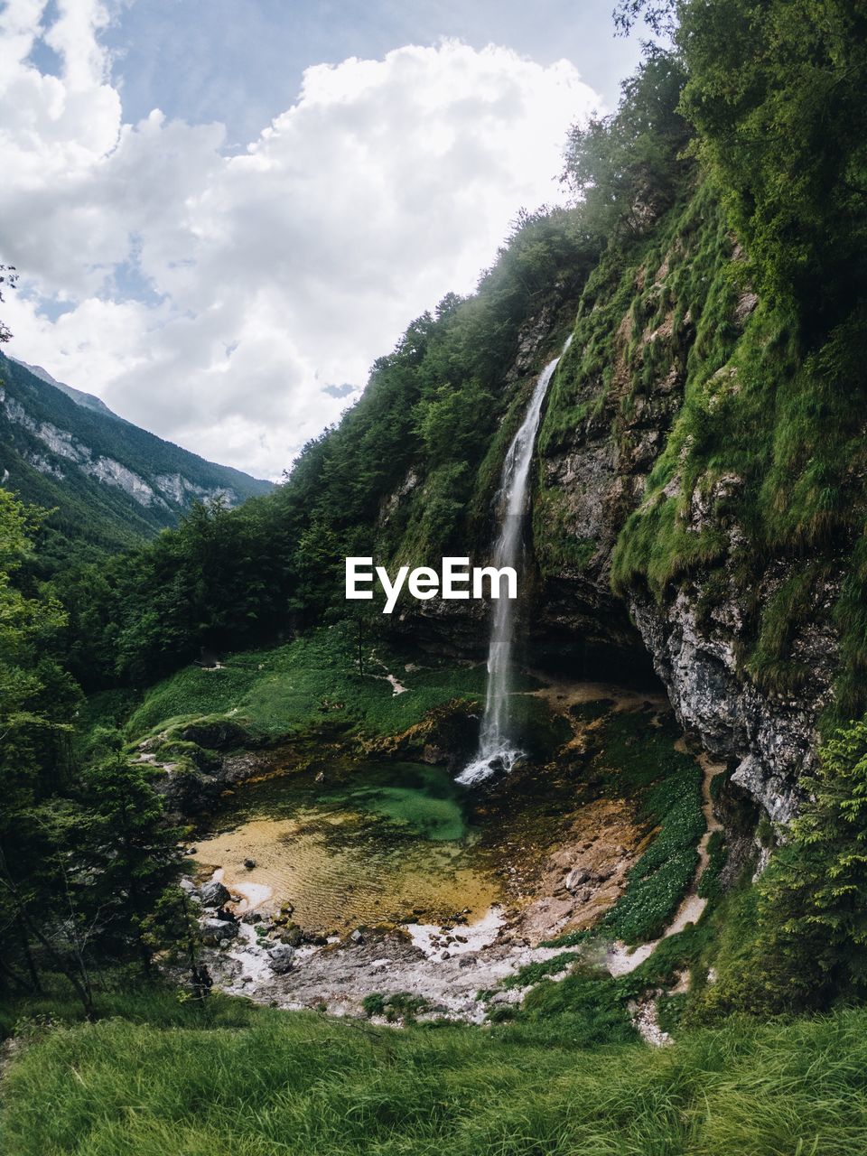 SCENIC VIEW OF WATERFALL AGAINST ROCKS