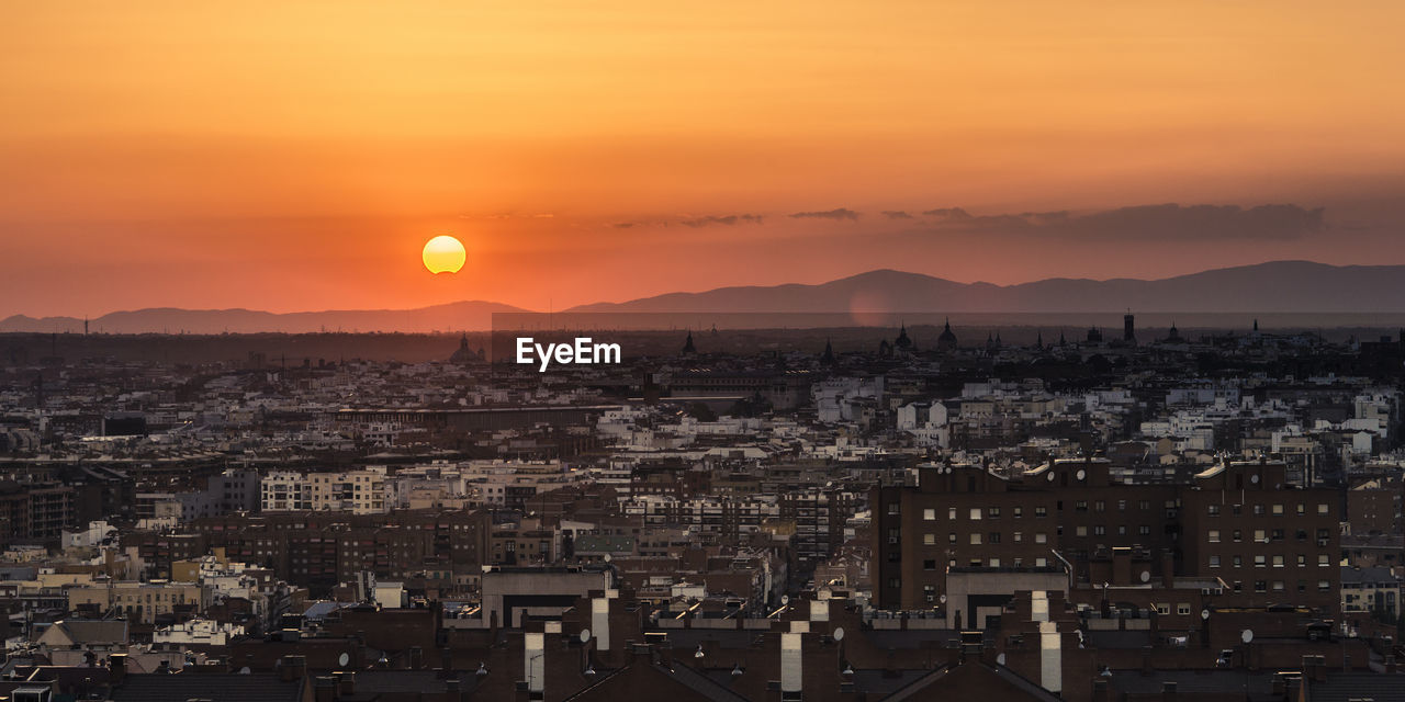 Partial sun eclipse over madrid skyline on a warm summer sunset