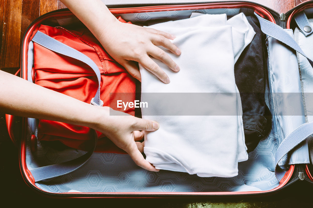 Cropped hands of person packing suitcase
