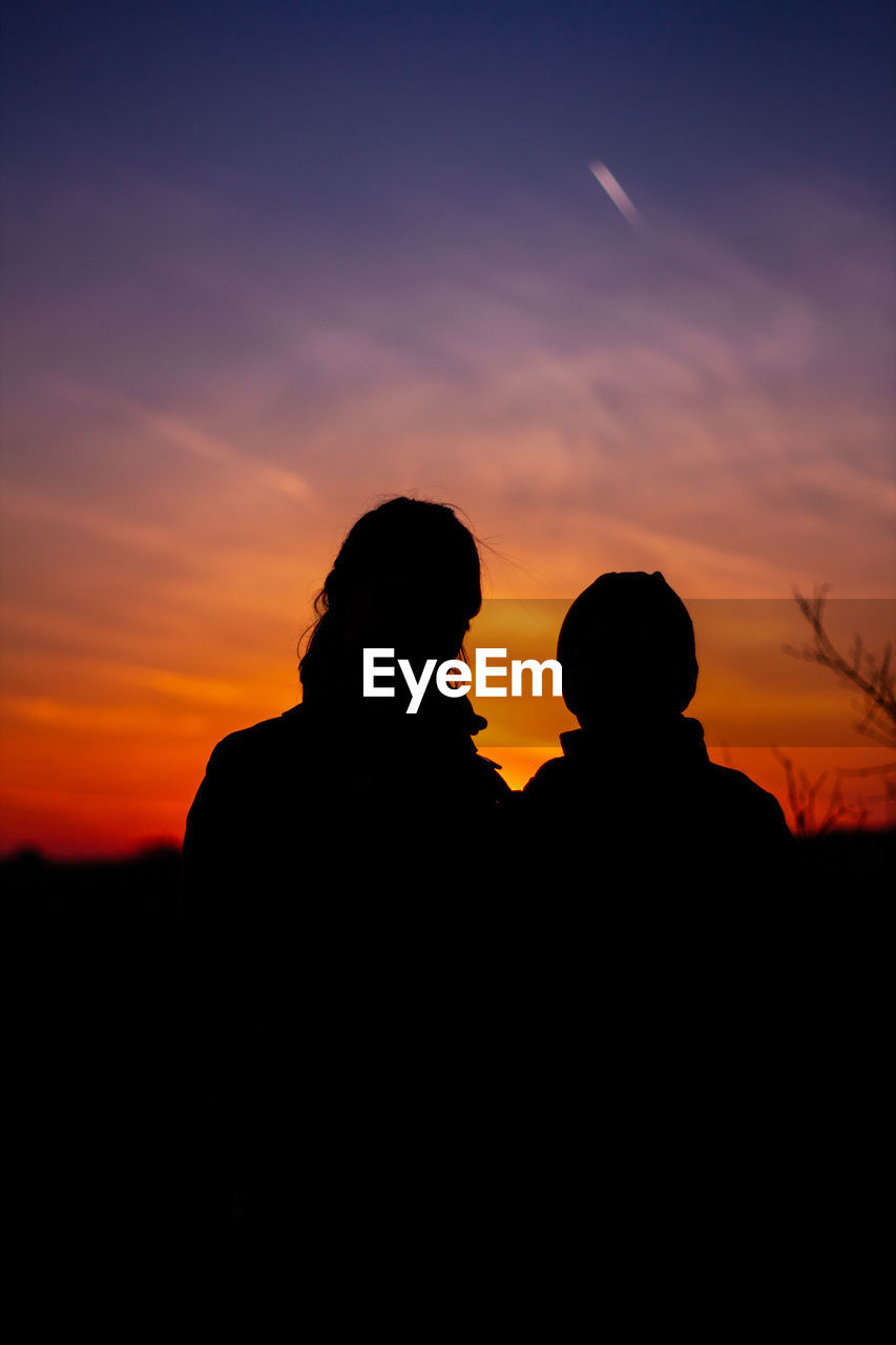 Silhouette couple against sky during sunset