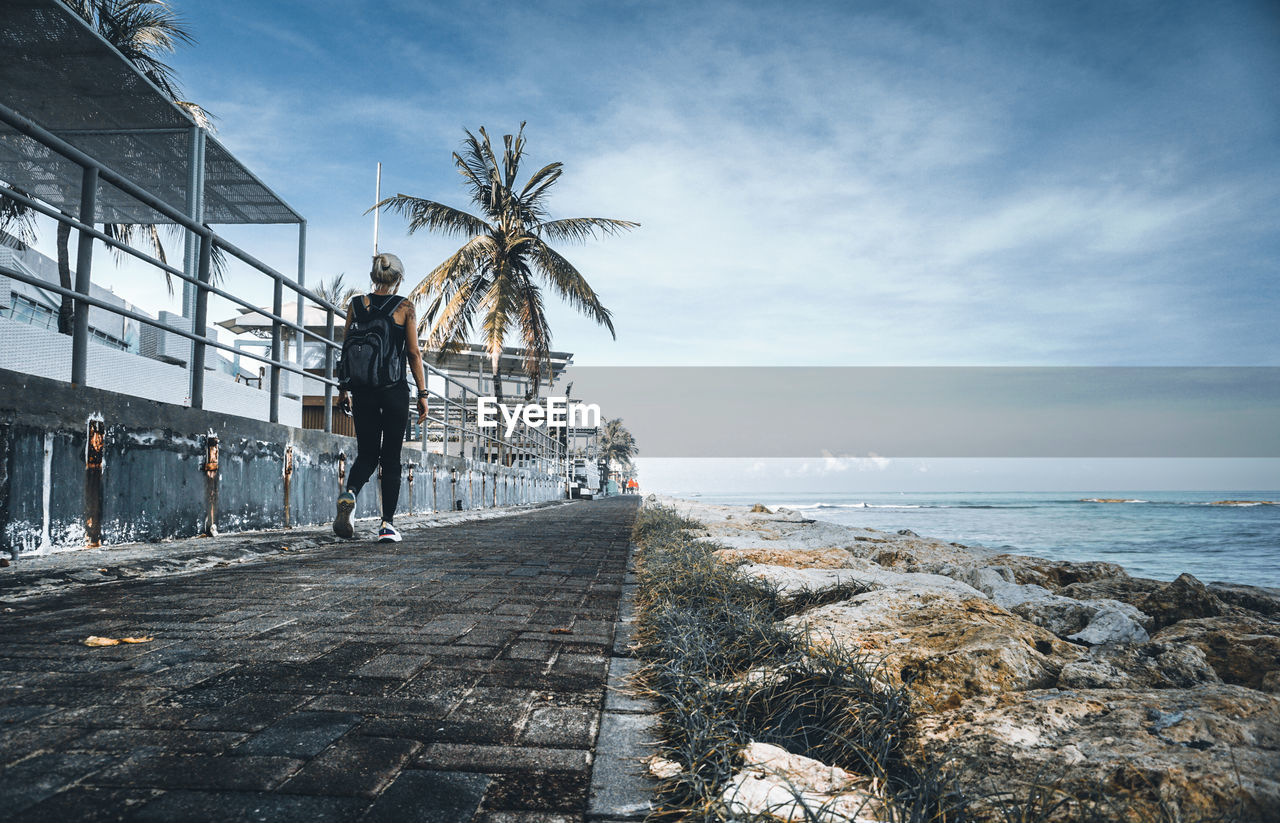 People on beach by sea against sky