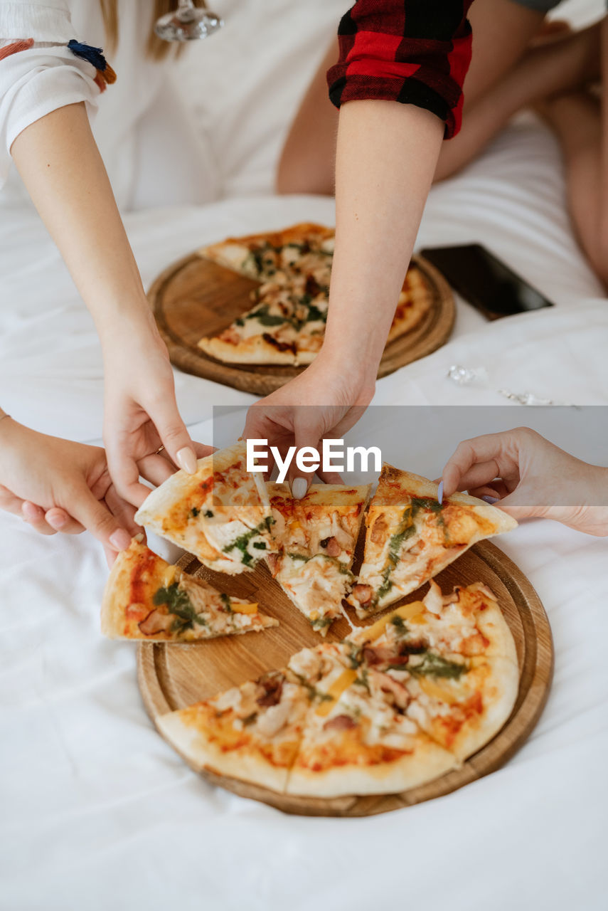 midsection of woman holding pizza on table