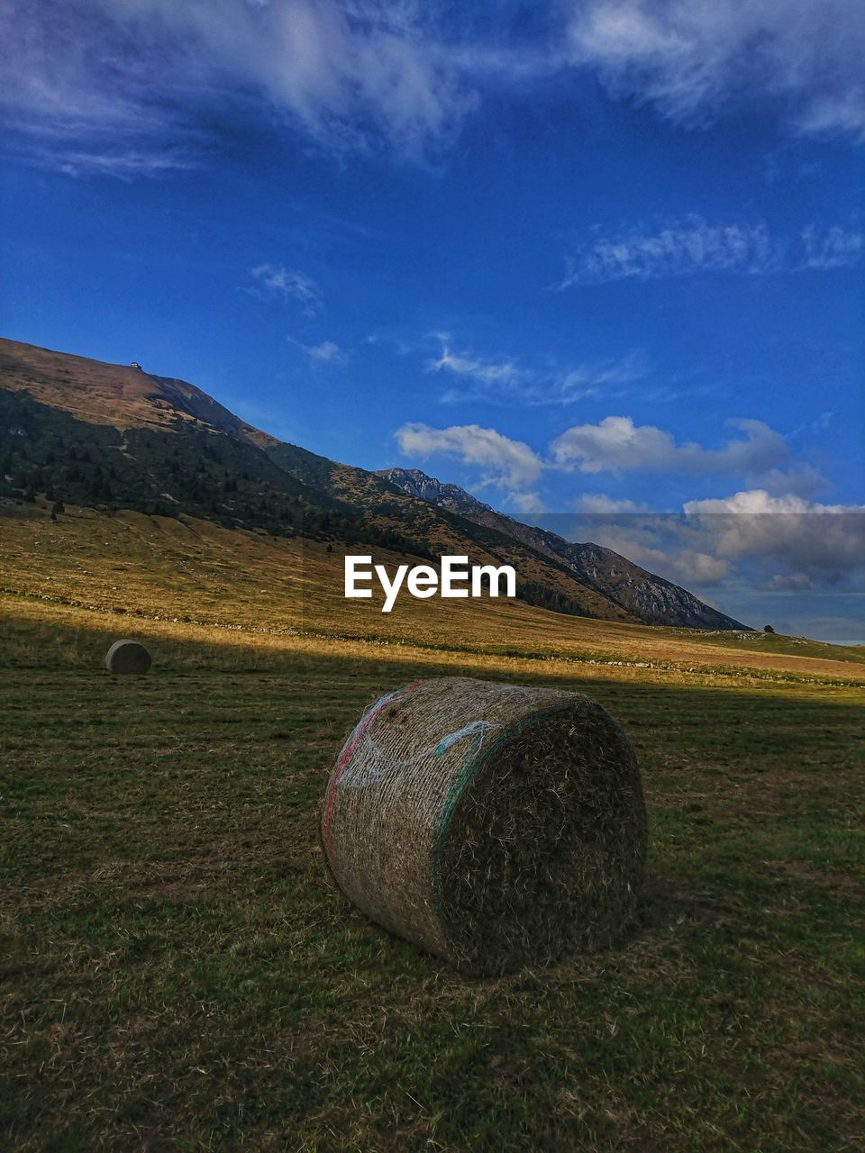 Hay bales on field against sky