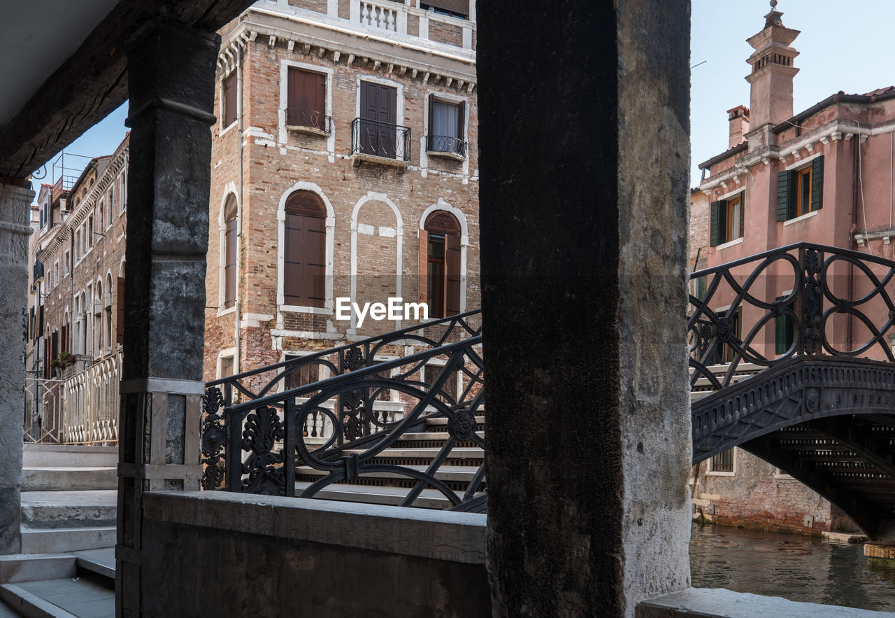 Winding street with bridge in venice with historical fassades in the background.