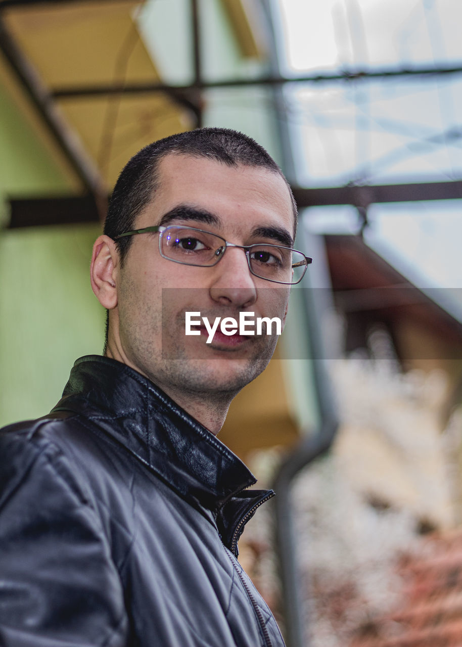 PORTRAIT OF YOUNG MAN WITH EYEGLASSES