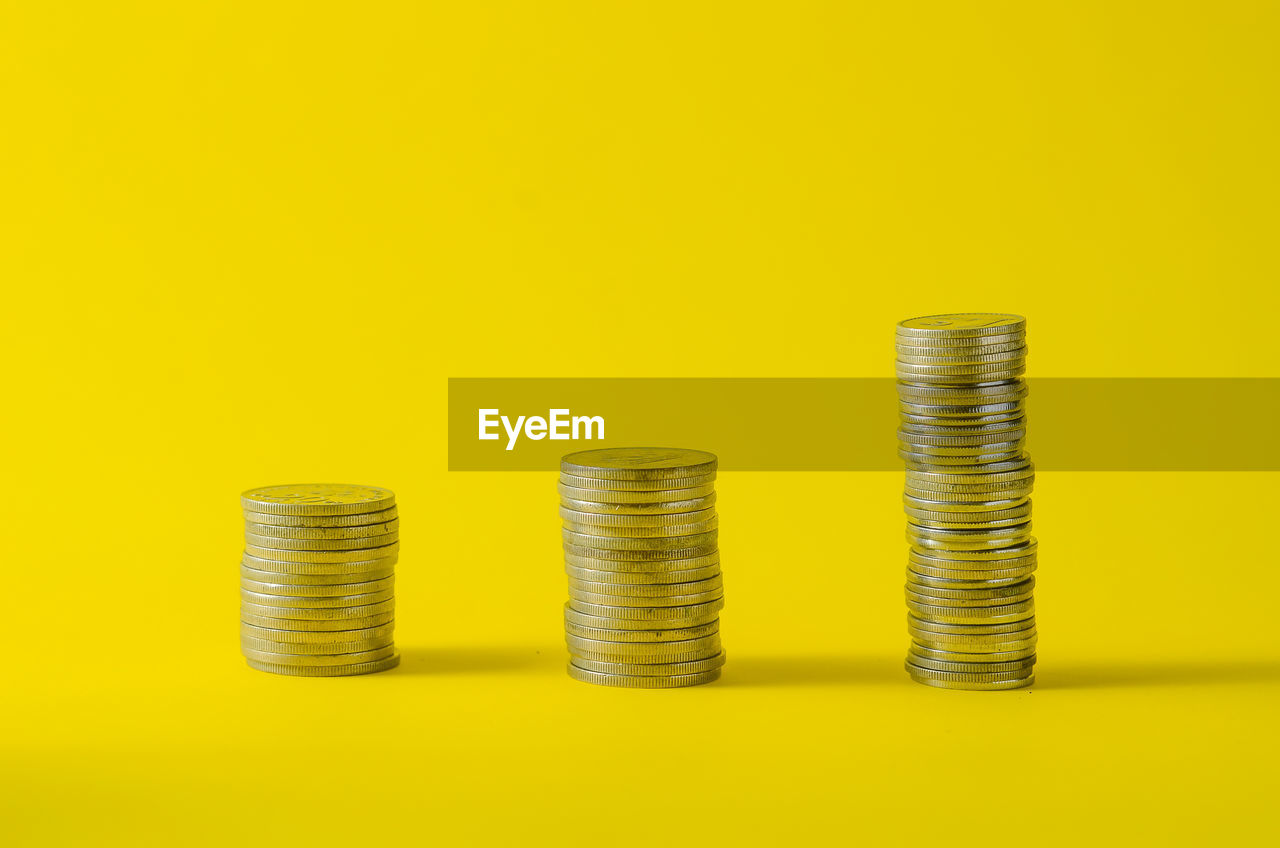 Close-up of coins on yellow background