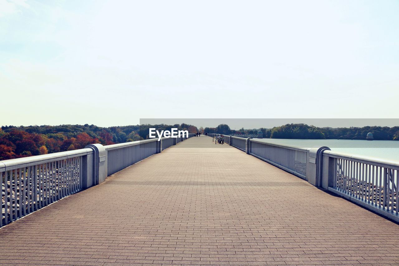 Surface level of footbridge against clear sky