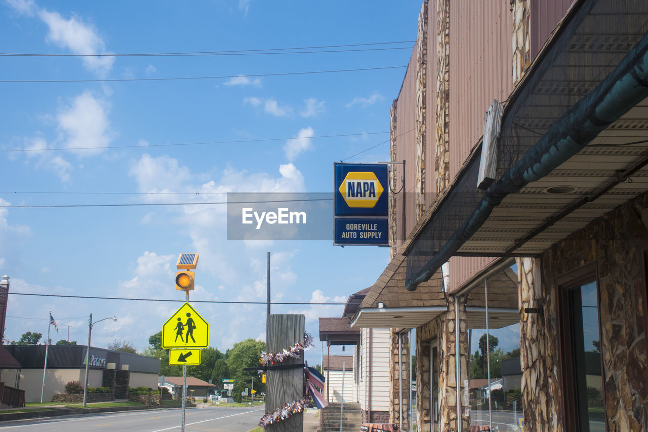 ROAD SIGN BY CITY AGAINST SKY