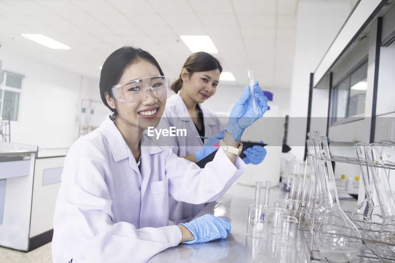 Portrait beautiful smiling scientist holding test tube at laboratory