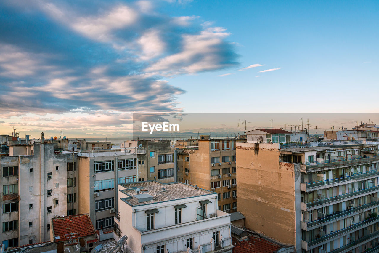 HIGH ANGLE VIEW OF BUILDINGS AGAINST SKY AT SUNSET