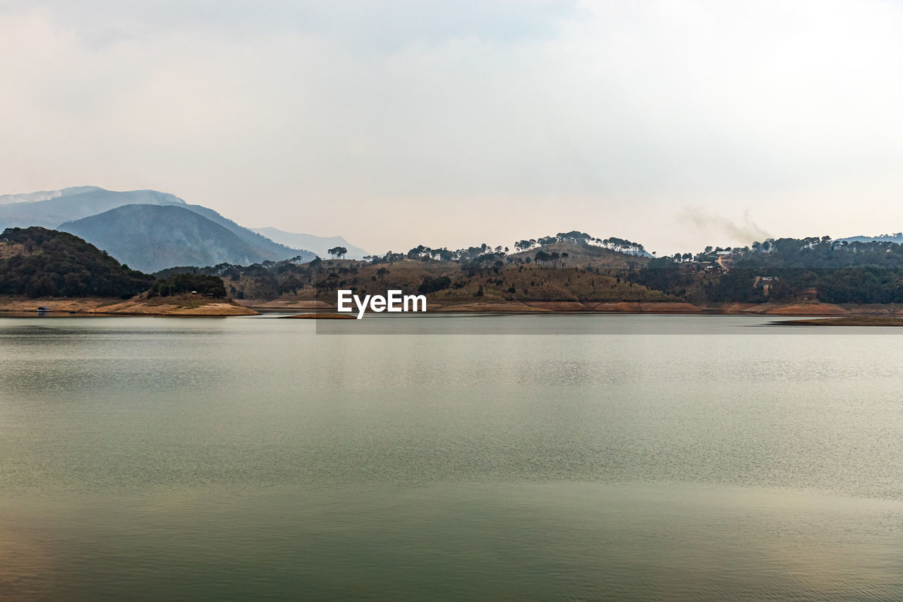 Lake calm water with mountain background at day from flat angle