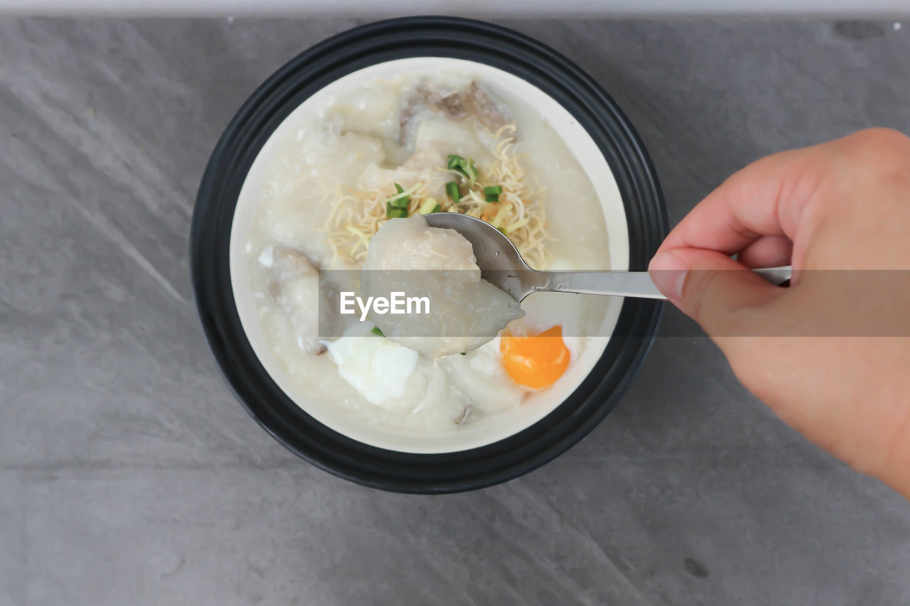 HIGH ANGLE VIEW OF PERSON HAVING FOOD IN BOWL