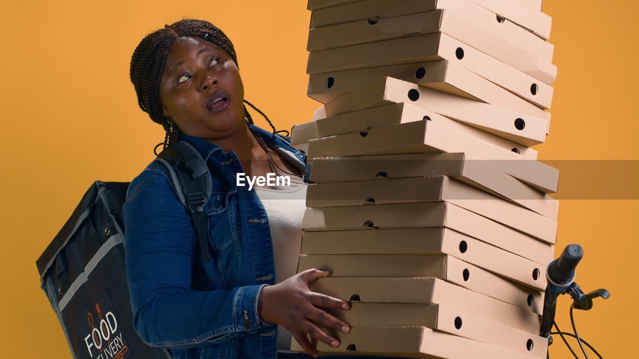 portrait of young woman standing against built structures