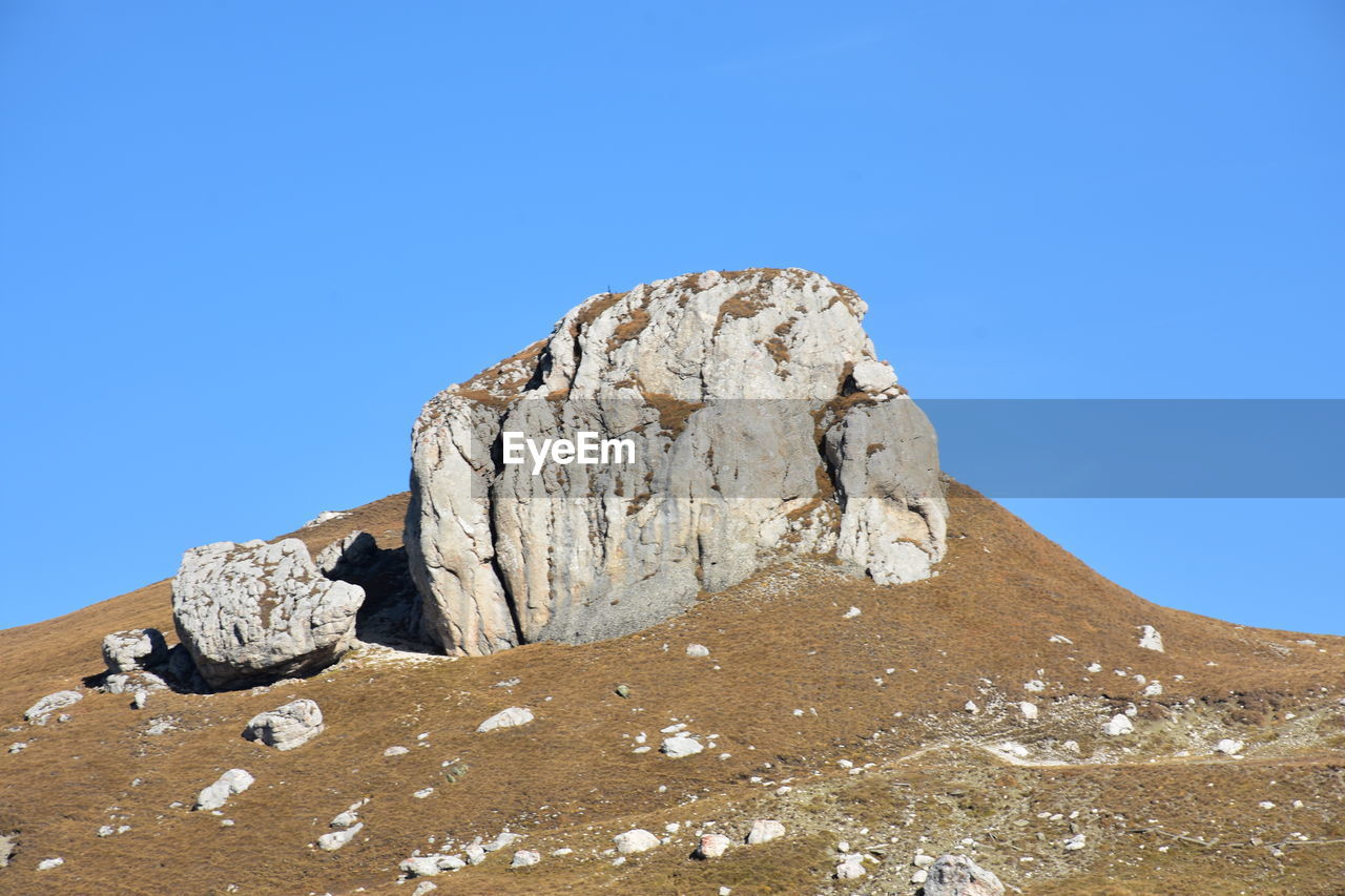 Rock formations on landscape against blue sky