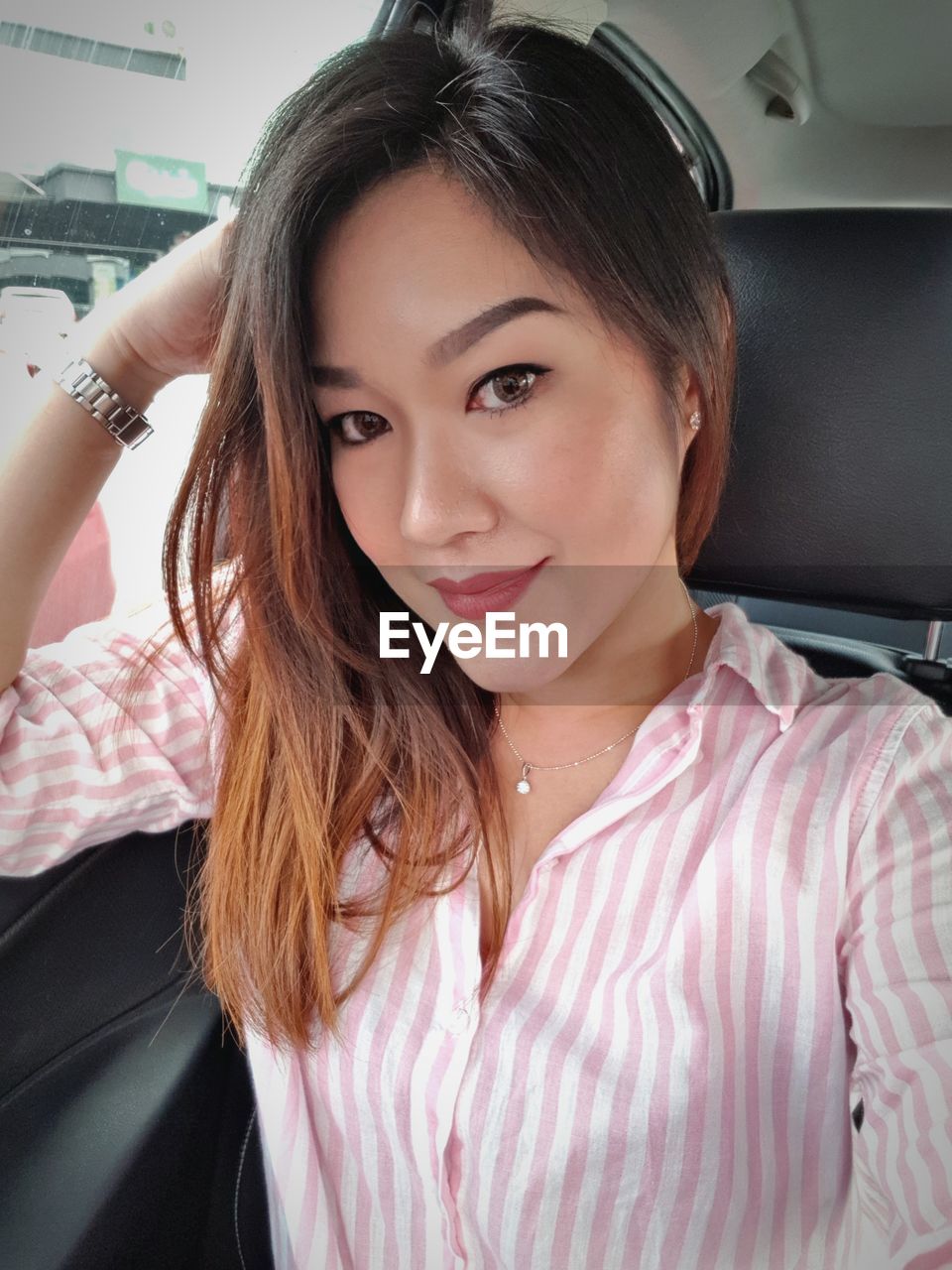 Portrait of beautiful young woman in car