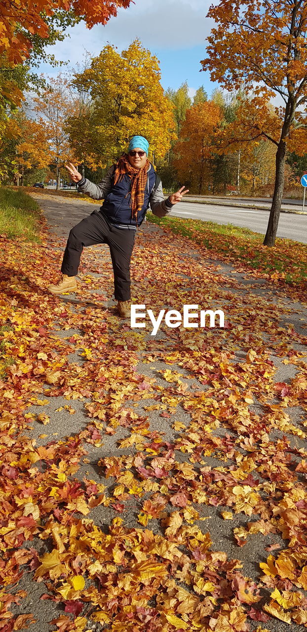 FULL LENGTH OF PERSON AMIDST LEAVES IN AUTUMN