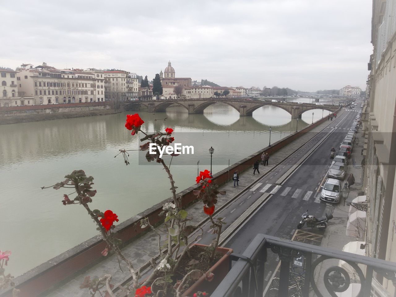 HIGH ANGLE VIEW OF ARCH BRIDGE OVER RIVER IN CITY AGAINST SKY