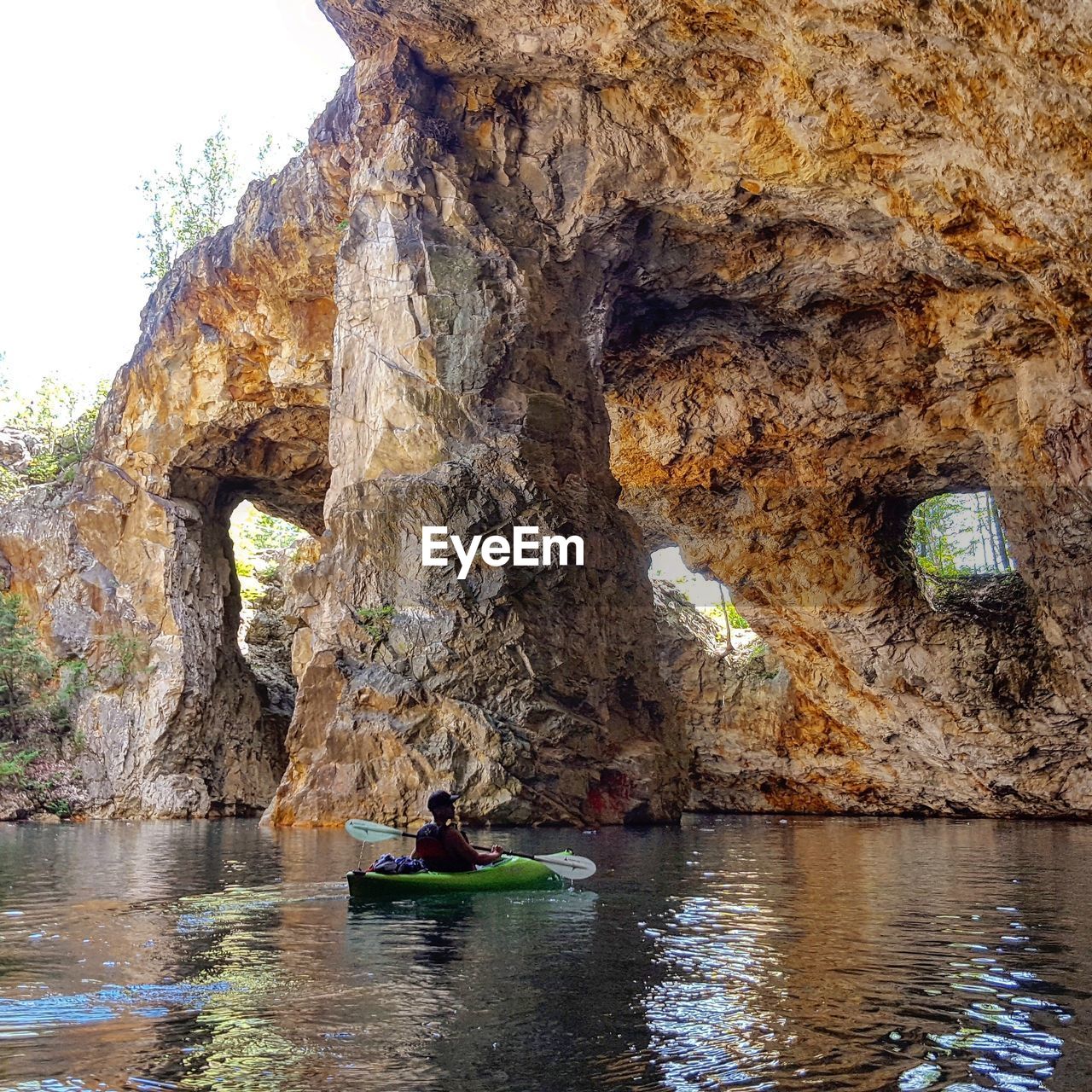 Man kayaking in lake amidst rock formation