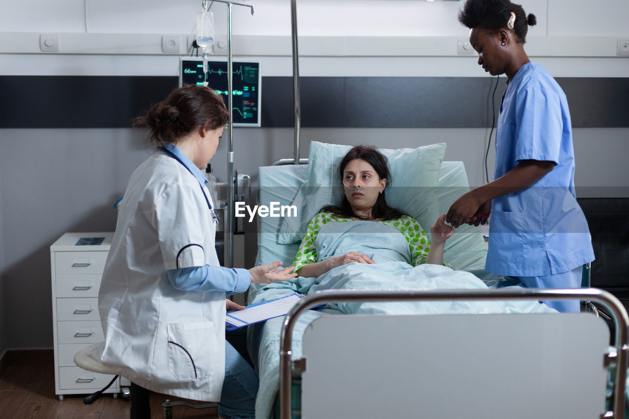 Nurse and doctor examining patient in hospital