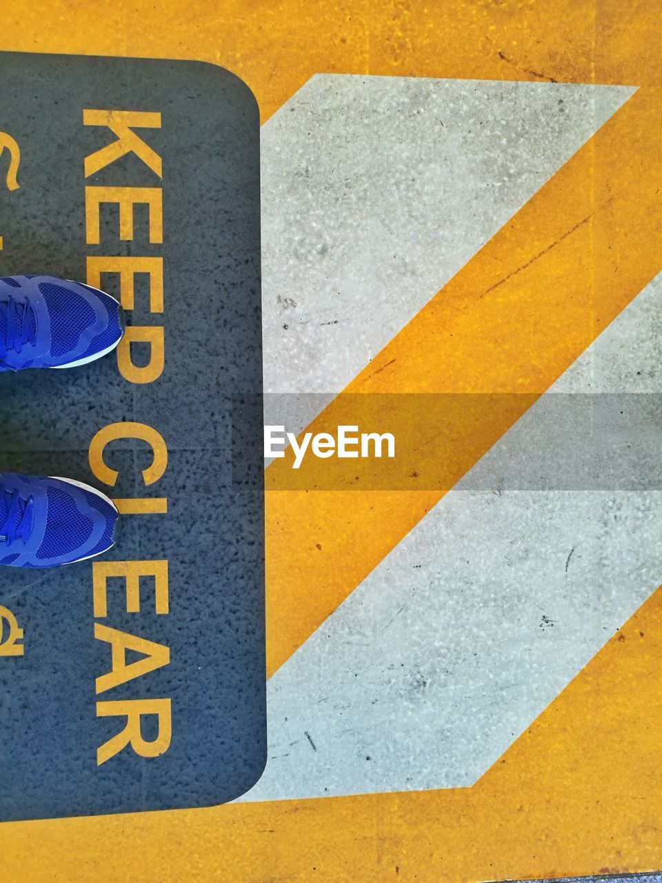 Low section of man standing on road sign 