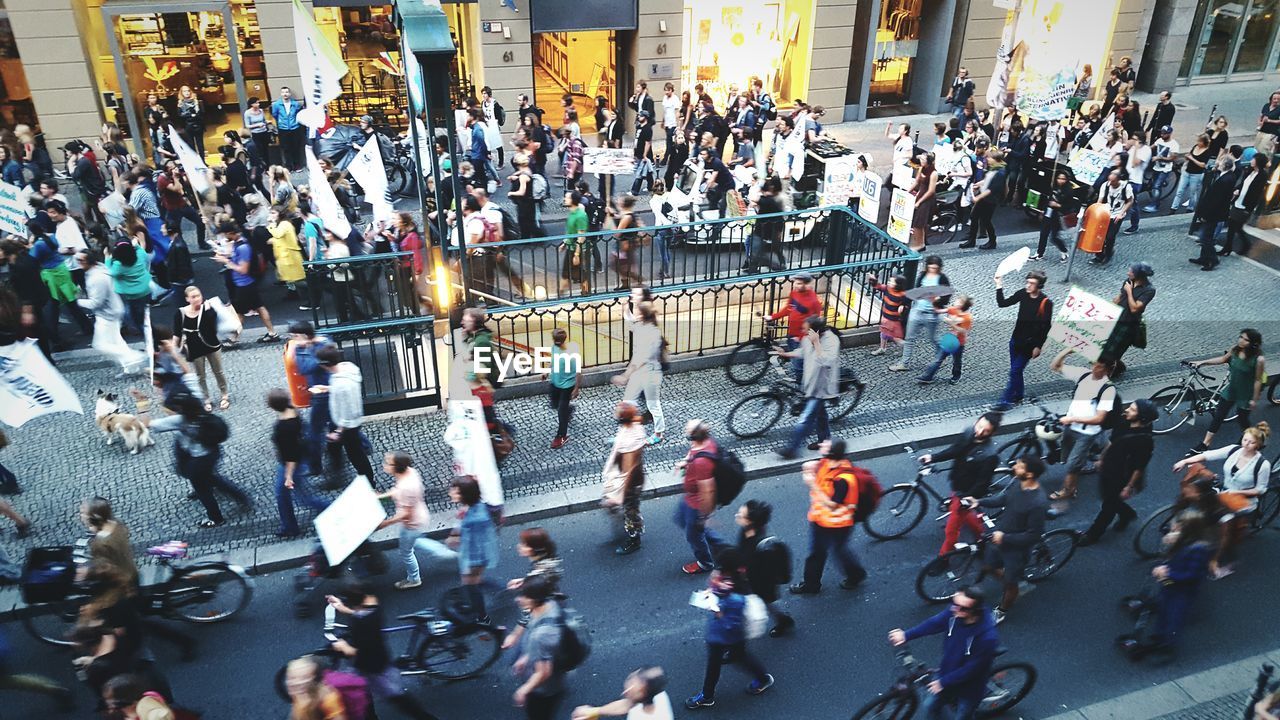 High angle view of people with bicycles walking on street in city