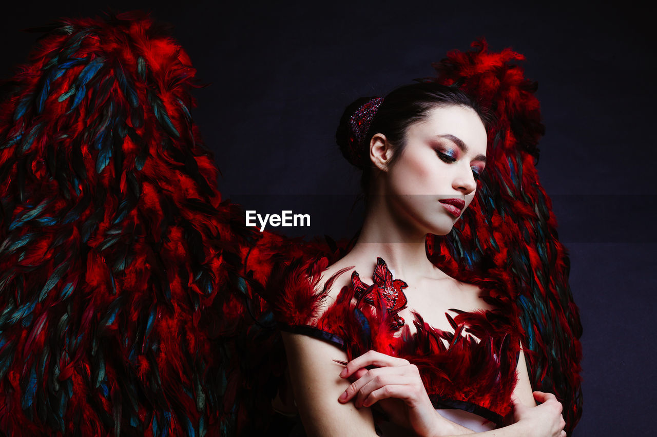 Beautiful woman with angel wings against black background