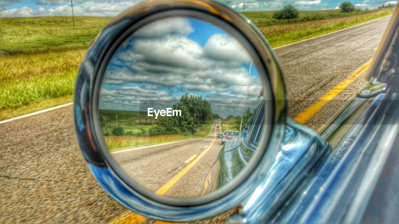 REFLECTION OF CAR ON SIDE-VIEW MIRROR