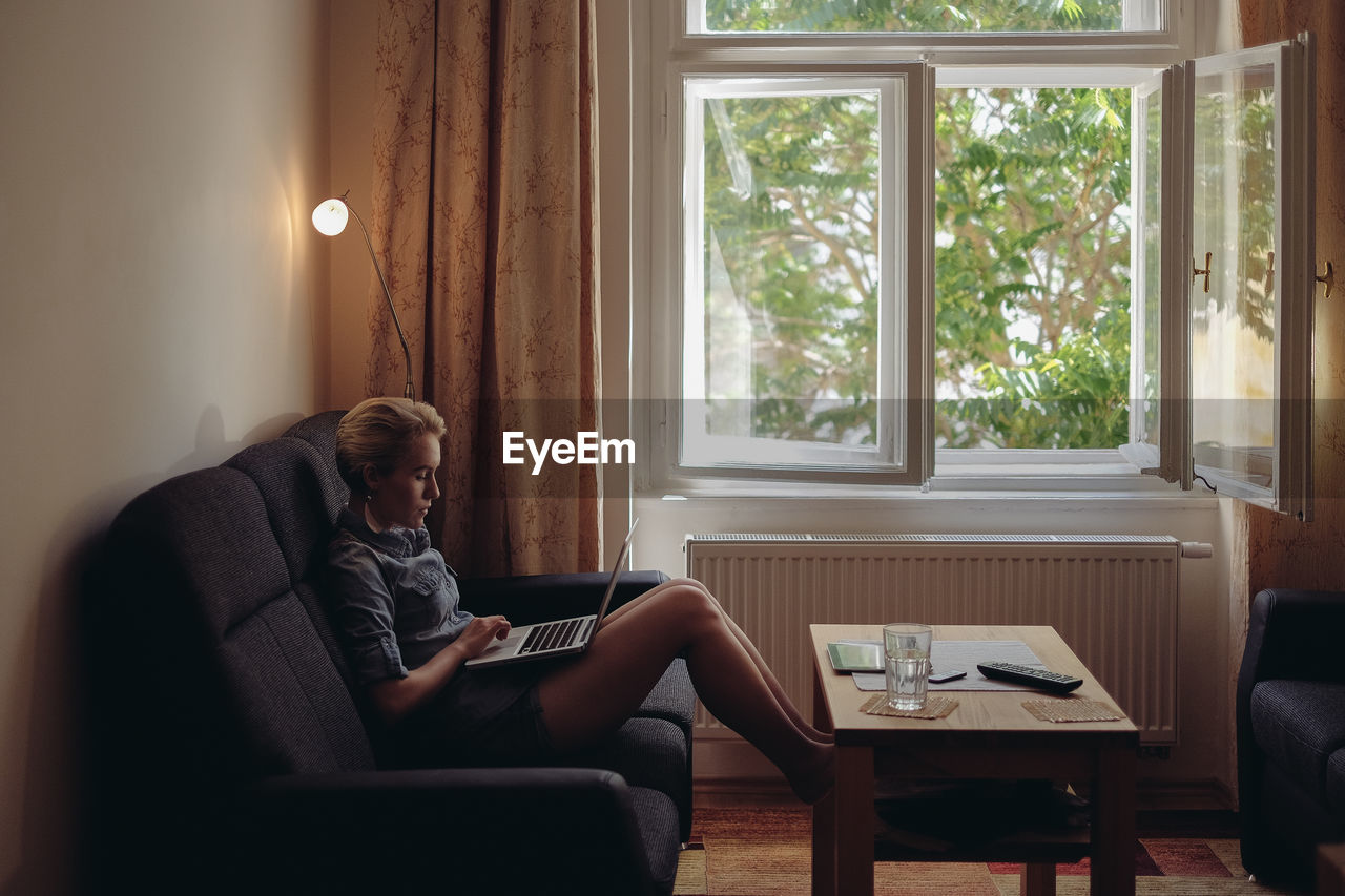 Woman using laptop in living room