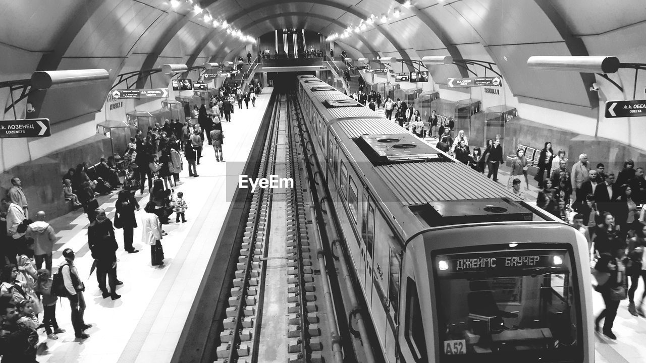 HIGH ANGLE VIEW OF PEOPLE AT SUBWAY STATION PLATFORM