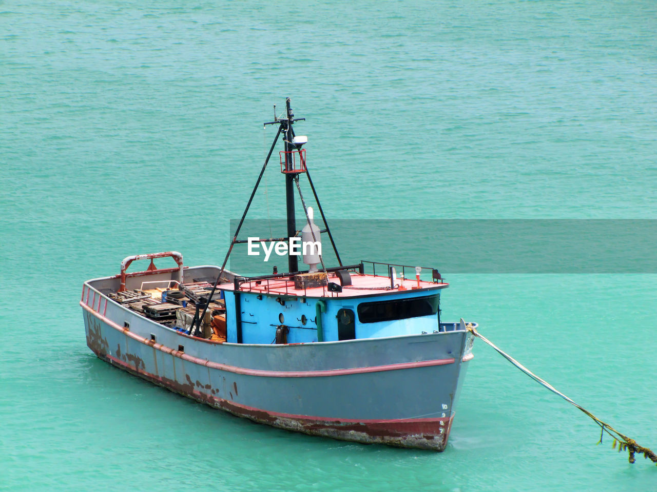 Old and rusty fishing boat anchored in the caribbeans
