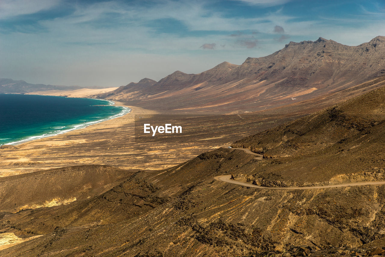 Scenic view of sea and mountains against sky