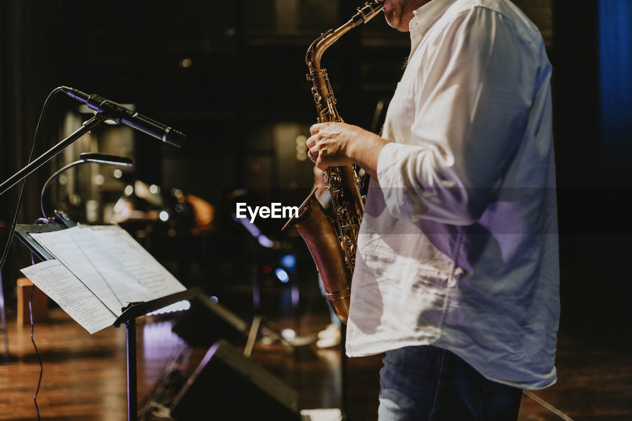 Midsection of playing saxophone at music concert