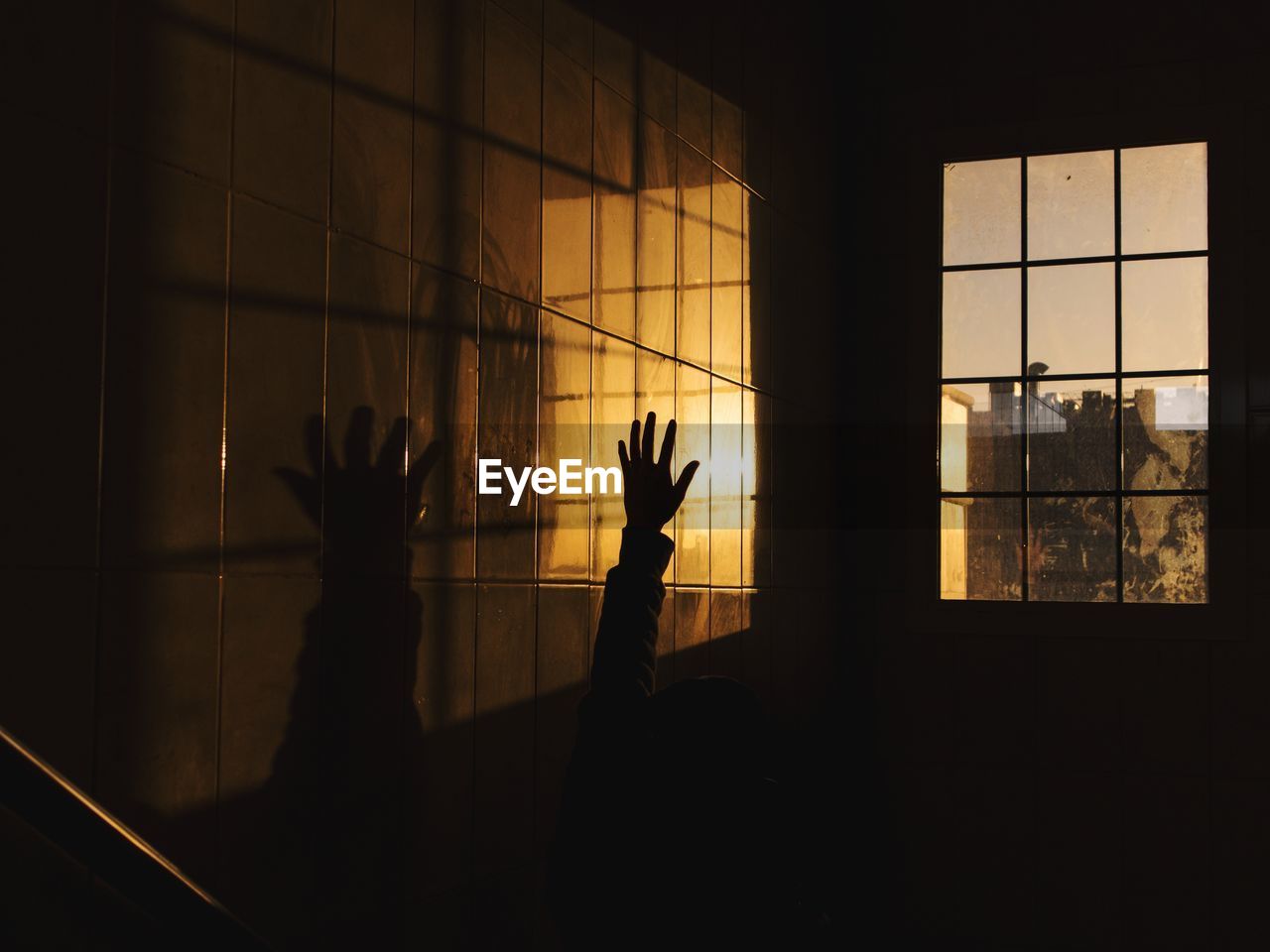 Silhouette people standing by window in dark room