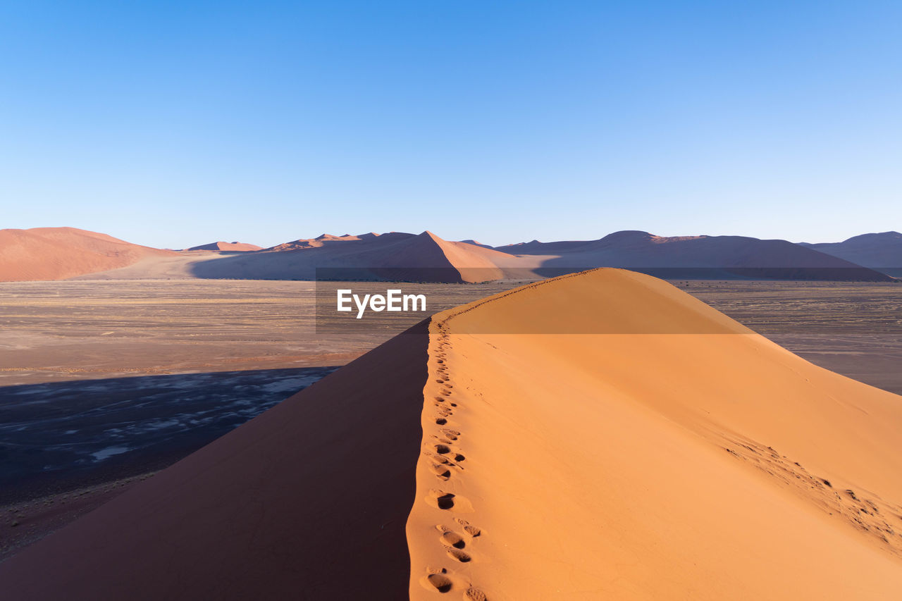 scenic view of desert against sky during sunset