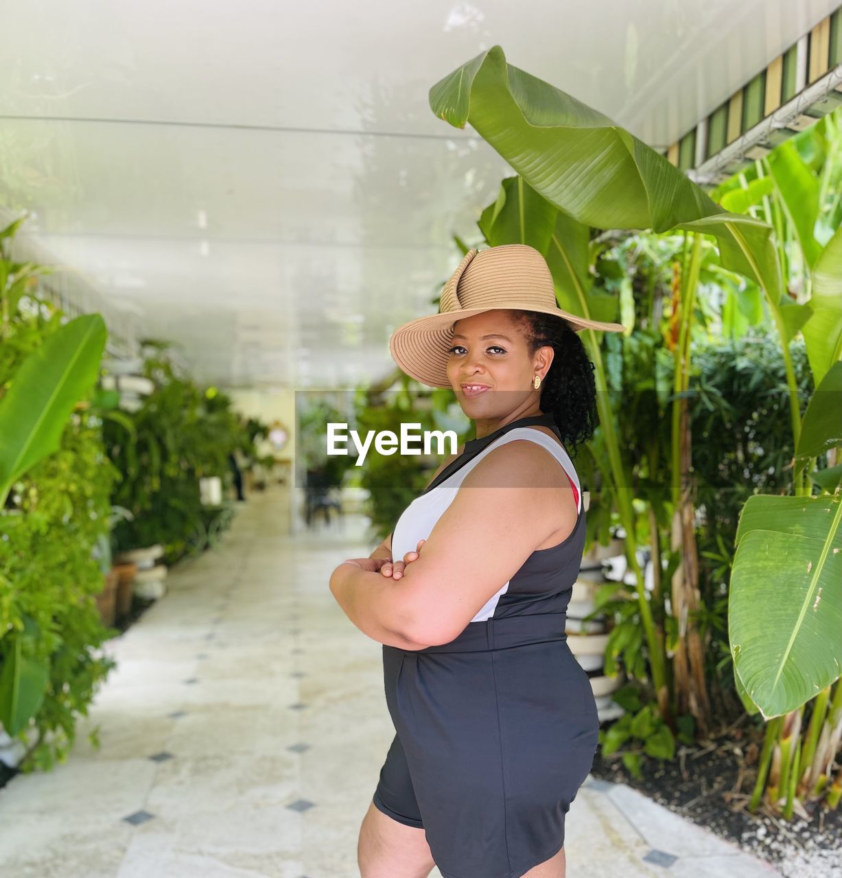 Portrait of young woman standing against plants