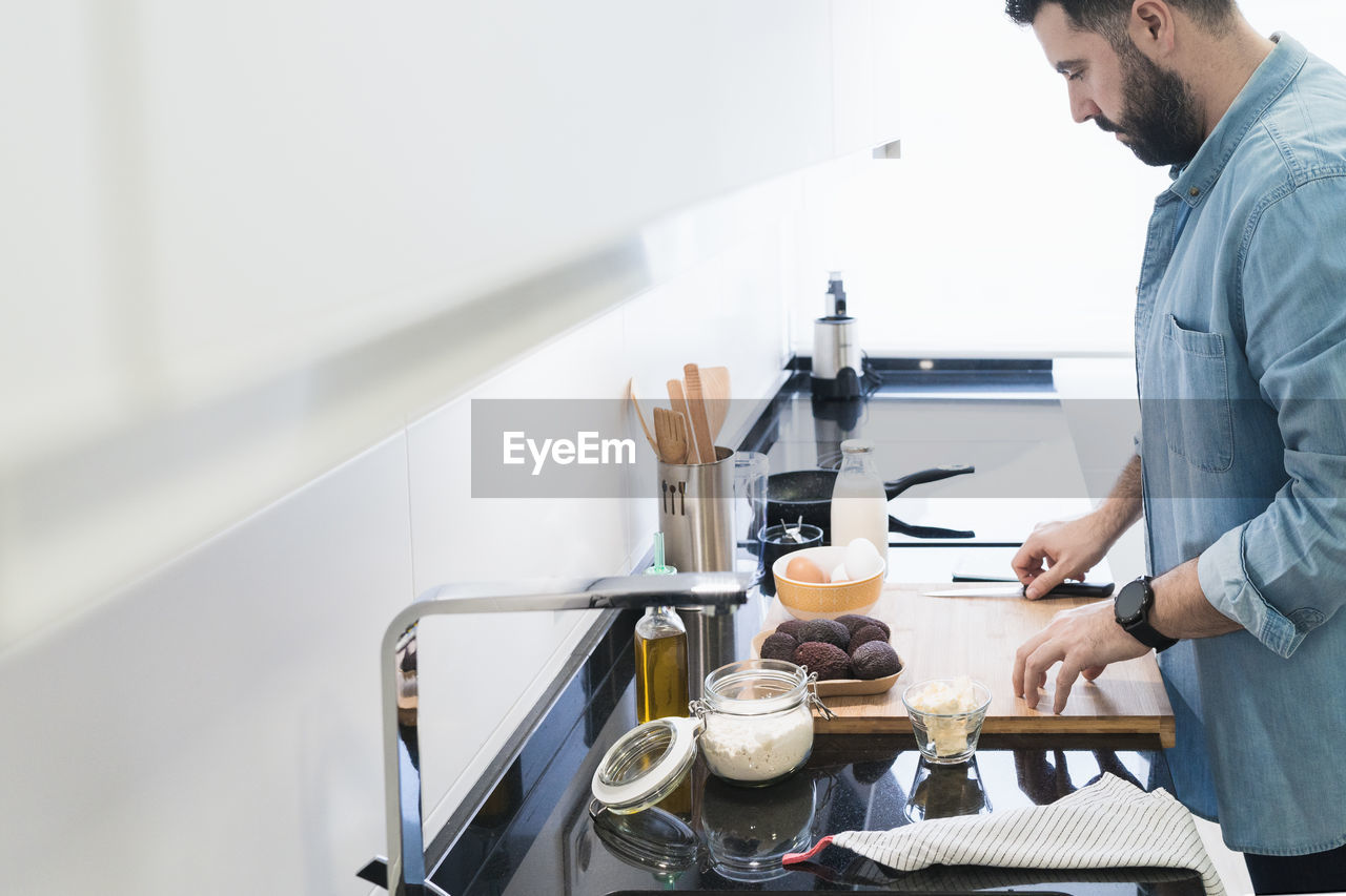 Man cooking in the kitchen in a denim shirt