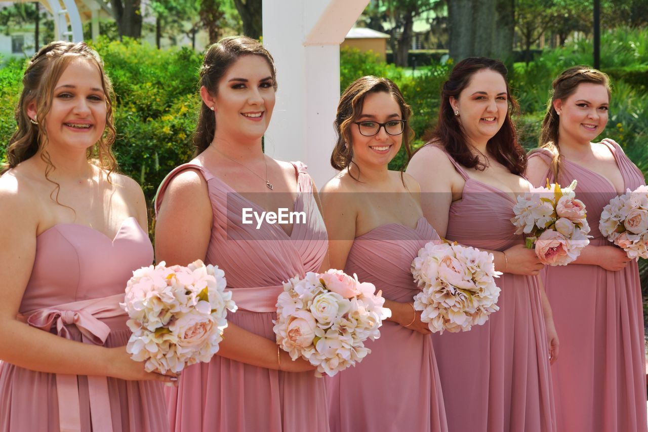 Portrait of bridesmaids holding bouquets