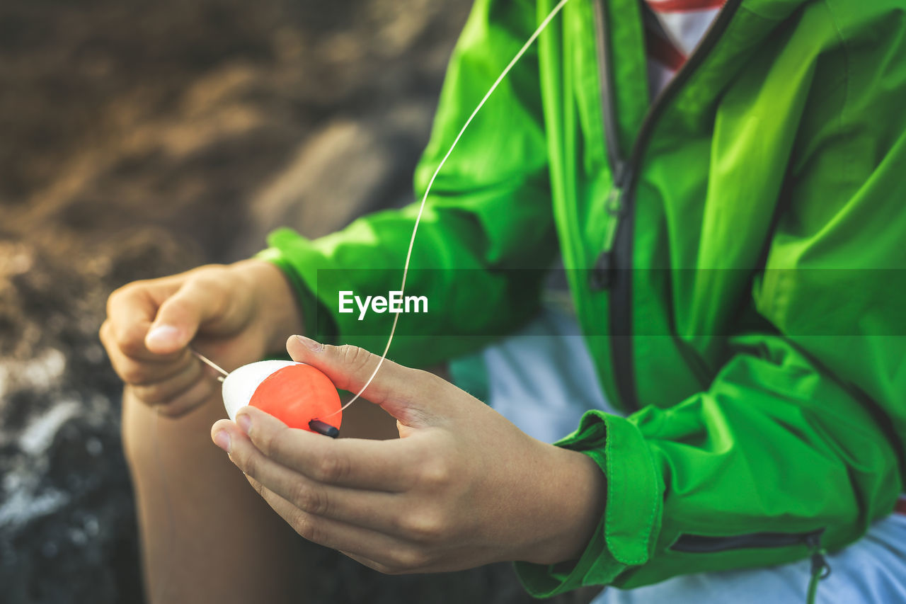 Midsection of man holding spinning top