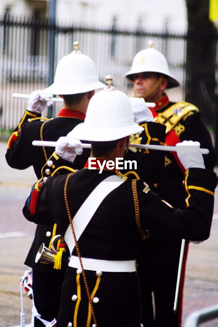 REAR VIEW OF PEOPLE IN TRADITIONAL CLOTHING OUTDOORS