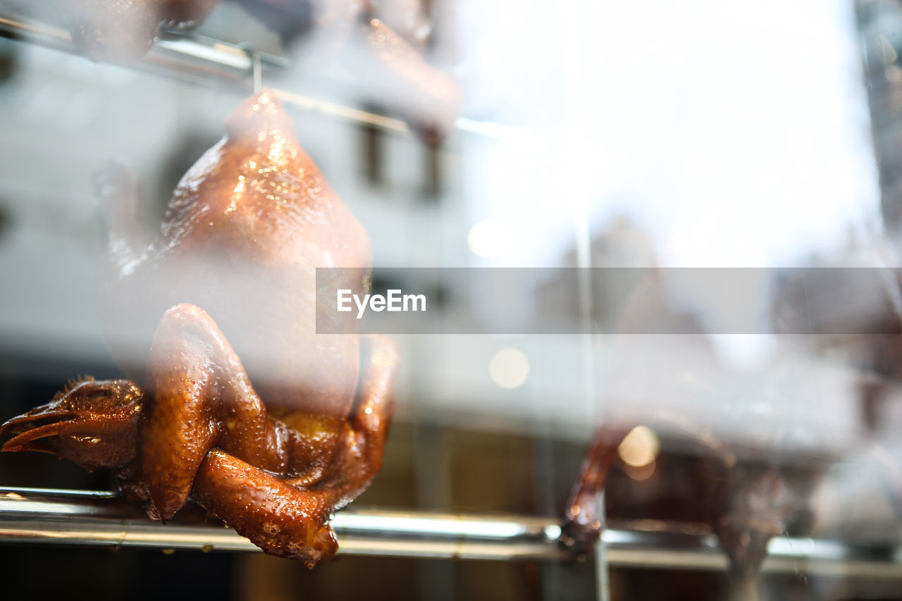 Close-up of roasted duck seen from glass window