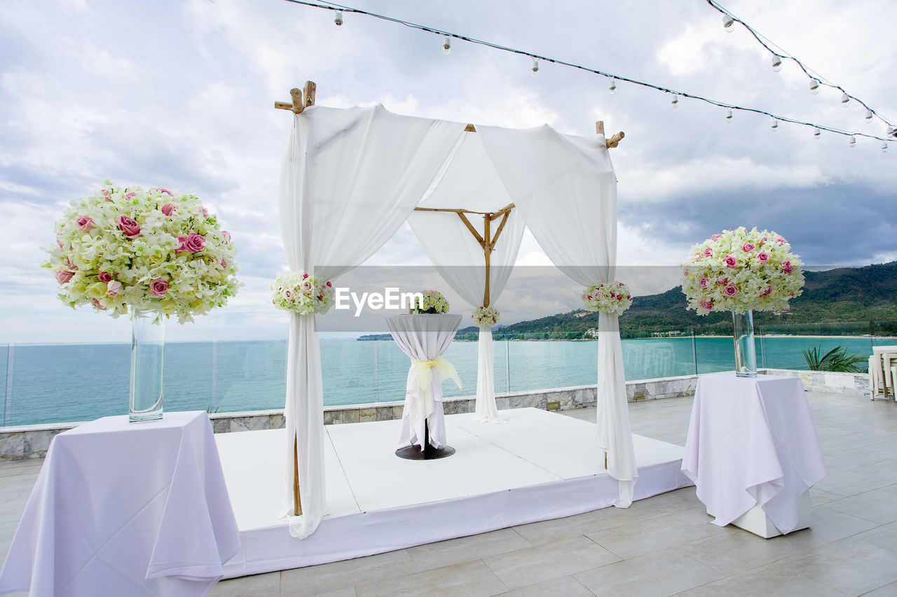 FLOWER POTS ON TABLE AGAINST SEA